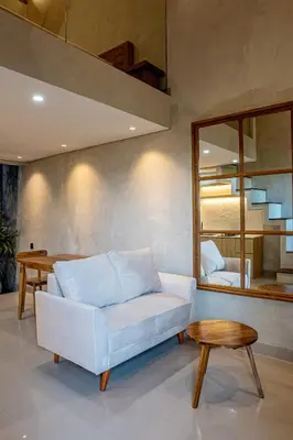 a living room with a white couch and a table at Green Loft Citarum in Sanur