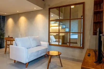a living room with a couch and a table and a mirror at Green Loft Citarum in Sanur