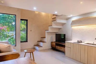 a kitchen with a staircase and a living room at Green Loft Citarum in Sanur