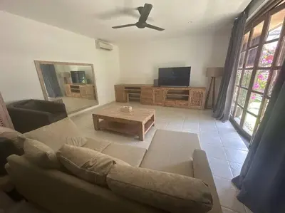 a living room with a couch and a tv at Villa Catta Seminyak in Legian