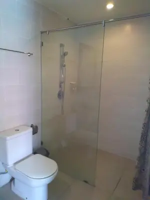 a bathroom with a toilet and a glass shower at Seminyak Apartment by LBV in Seminyak