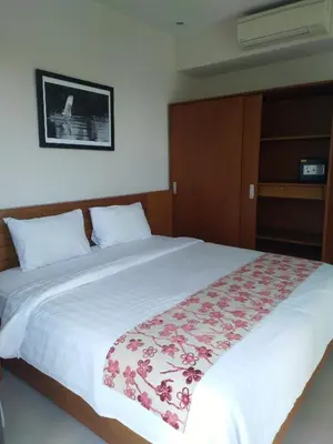 a bedroom with a large white bed with flowers on it at Seminyak Apartment by LBV in Seminyak
