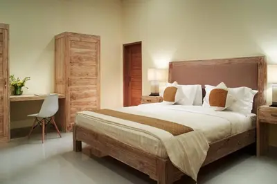 a bedroom with a large bed and a desk at Sol Bella Villa 2 in Seminyak