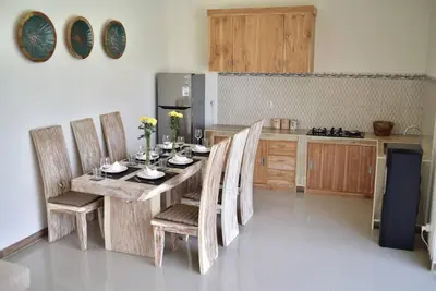a kitchen with a wooden table and chairs in a room at Sol Bella Villa 2 in Seminyak