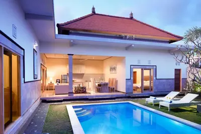 a house with a swimming pool in front of a house at Sol Bella Villa 3 in Seminyak