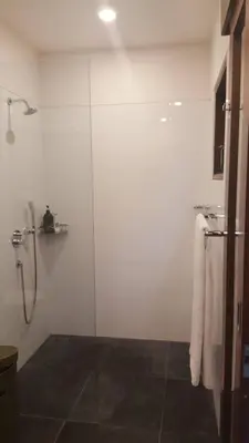 a bathroom with a shower with a glass door at ViLLA GREEN MANGGO III in Seminyak