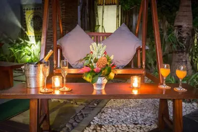 a table with glasses and a vase of flowers and candles at ViLLA GREEN MANGGO III in Seminyak