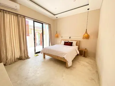 a bedroom with a bed and a large window at Luminara villa in Canggu