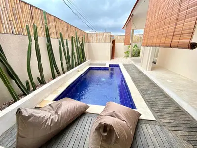 a small swimming pool with pillows on a wooden deck at Luminara villa in Canggu