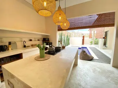 a kitchen with a counter top and some lights at Luminara villa in Canggu