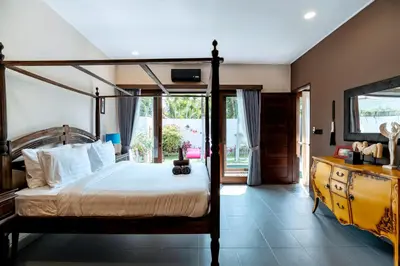 a bedroom with a canopy bed and a television at Villa Damira in Seminyak