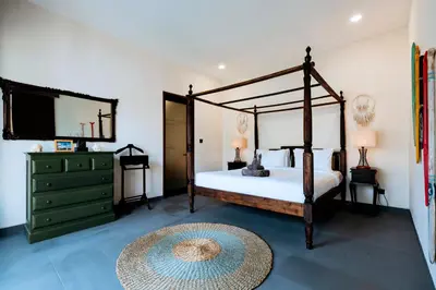 a bedroom with a canopy bed and a mirror at Villa Damira in Seminyak