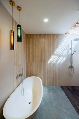 a white bath tub in a bathroom with lights at Villa Damira in Seminyak
