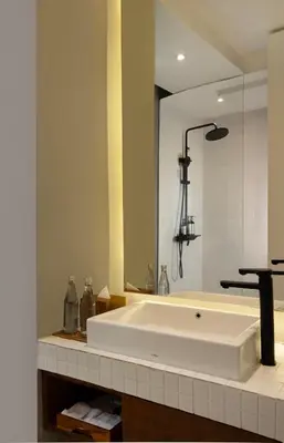 a bathroom with a large white tub and a mirror at Dialoog Seminyak in Seminyak