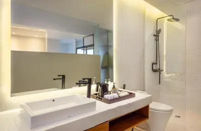 a white bathroom with a sink and a toilet at Dialoog Seminyak in Seminyak