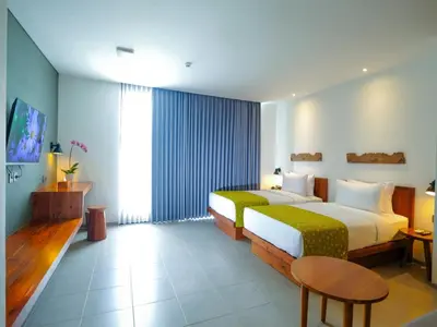 a hotel room with two beds and a table at Dialoog Seminyak in Seminyak