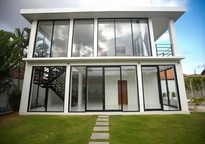 a house with large glass windows and a staircase at Villa Noeul Seminyak - Fast Wifi And Private Pool in Seminyak