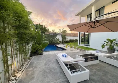 a patio with a table and chairs and an umbrella at Villa Noeul Seminyak - Fast Wifi And Private Pool in Seminyak