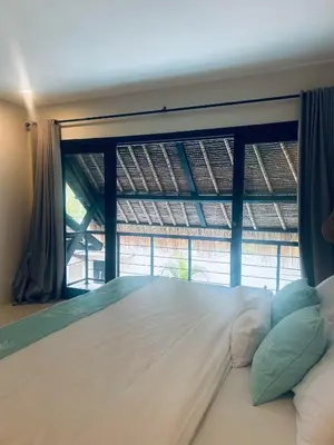 a bedroom with a large bed with a large window at Villa Malicott Athena - 3C in Seminyak