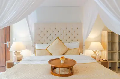 a bedroom with a large bed with a table at Akhira One Seminyak in Seminyak