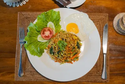 a plate of food with an egg and a salad at Akhira One Seminyak in Seminyak