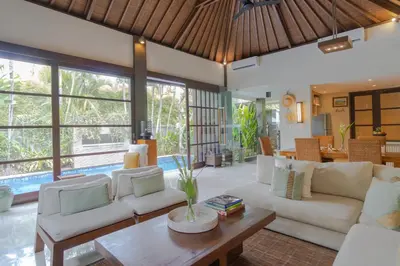 a living room with white couches and a table at Akhira One Seminyak in Seminyak