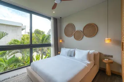 a bedroom with a bed and a large window at Villa Amanora & Amaluna - 2 Stunning Villas, 9 Bedrooms for Groups in Canggu