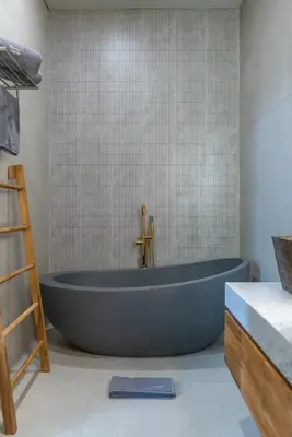 a large blue bath tub in a bathroom at Villa Amanora & Amaluna - 2 Stunning Villas, 9 Bedrooms for Groups in Canggu