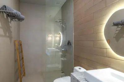a bathroom with a shower and a toilet and a sink at Villa Amanora & Amaluna - 2 Stunning Villas, 9 Bedrooms for Groups in Canggu