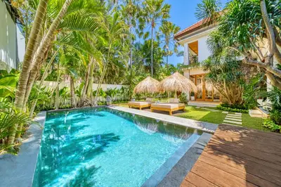 a swimming pool in front of a house with palm trees at Villa Chicago Brand new 7 BDR private pool in Seminyak