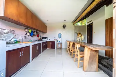 a large kitchen with a wooden table and chairs at Ayu Guest House 2 in Canggu