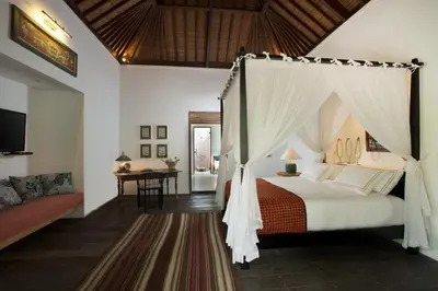a bedroom with a canopy bed and a table at Villa Mamoune in Umalas