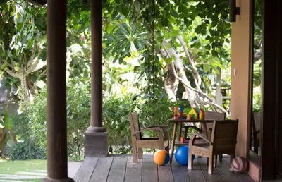 a table and chairs with balls on a porch at Villa Mamoune in Umalas