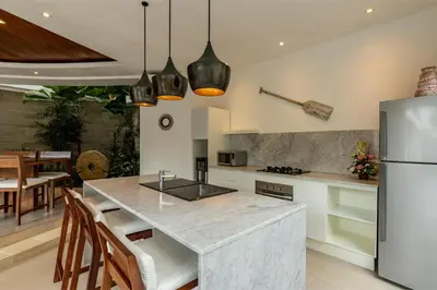 a kitchen with a counter and a refrigerator at Spacious 4BR Villa with Pool in Central Seminyak in Seminyak