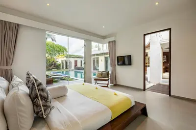 a bedroom with a large bed and a large window at Spacious 4BR Villa with Pool in Central Seminyak in Seminyak