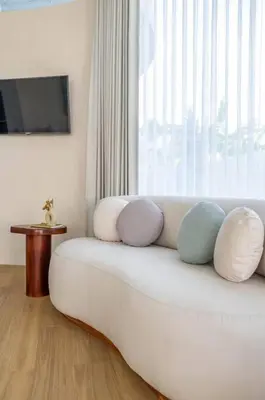 a white couch with pillows on it in front of a window at Uniquely designed 1bd villa with Pvt Pool in Umalas