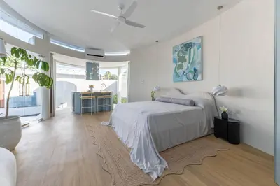 a white bedroom with a bed and a ceiling fan at Uniquely designed 1bd villa with Pvt Pool in Umalas