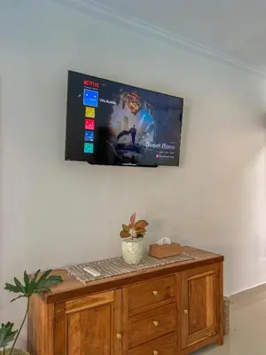 a flat screen tv hanging on a wall at Bubble Villa & Rice field view in Kerobokan