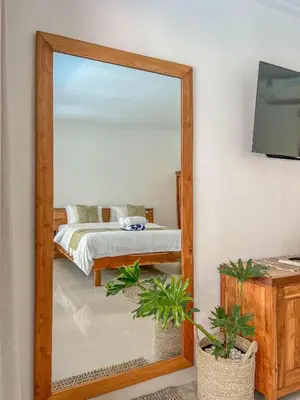 a mirror in front of a bedroom with a bed at Bubble Villa & Rice field view in Kerobokan
