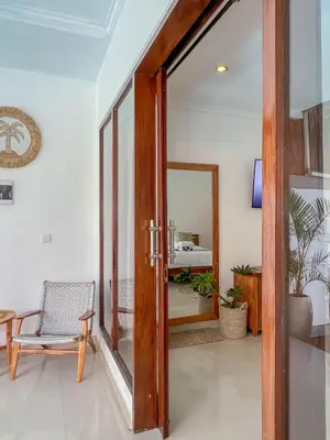 an open door into a room with a chair and a mirror at Bubble Villa & Rice field view in Kerobokan