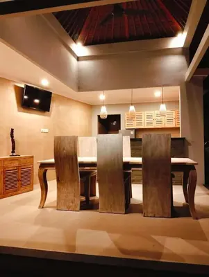 a dining room with a wooden table and chairs at De Jaya in Kerobokan