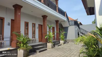 a building with pillars and plants in a courtyard at De Jaya in Kerobokan