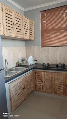 a kitchen with wooden cabinets and a sink at De Jaya in Kerobokan