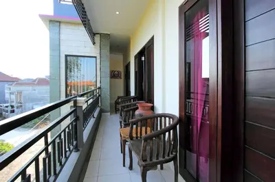 a balcony with wooden benches and a window at Ramantika Bali House in Jimbaran