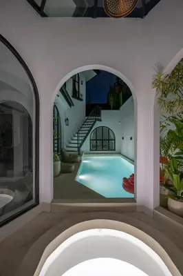 an indoor pool in a house with an archway at Villa Adela 1 Berawa 3BR Villa Near Atlas, Finns Beach Clubs in Canggu