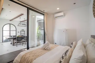 a bedroom with a large bed and a dining room at Villa Adela 1 Berawa 3BR Villa Near Atlas, Finns Beach Clubs in Canggu