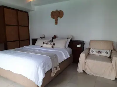 a bedroom with two beds and a chair at Rove One-bedroom Pool Villa Seminyak in Seminyak