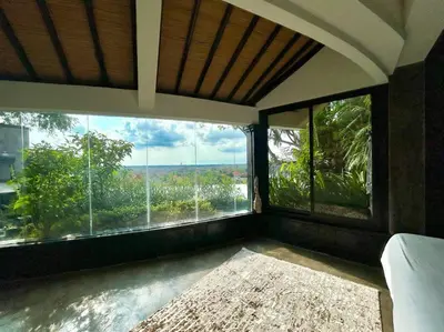a room with large windows with a view of trees at Sunset view apartment in Nusa Dua in Nusa Dua