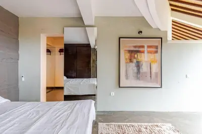 a bedroom with two beds and a painting on the wall at Sunset view apartment in Nusa Dua in Nusa Dua