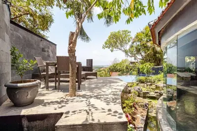a patio with a table and chairs and a tree at Sunset view apartment in Nusa Dua in Nusa Dua